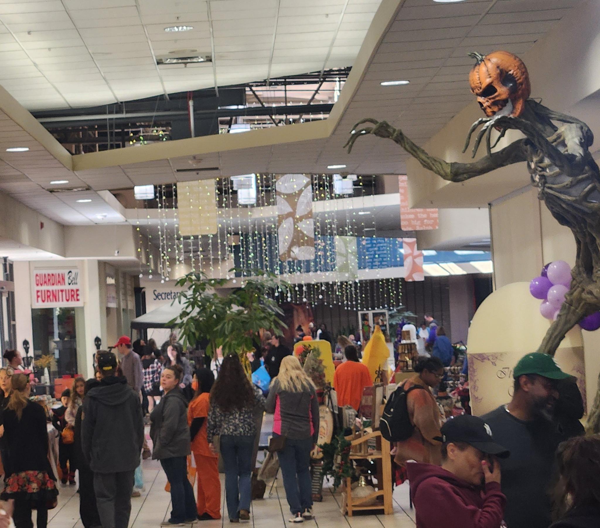 Costumed shoppers exploring stores and vendor displays at Jackson Crossing during Malloween.