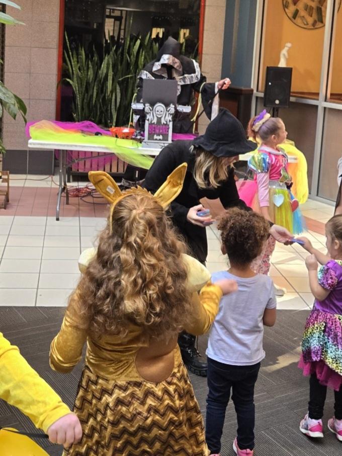 Halloween costumes and family activities beside the Malloween DJ booth.