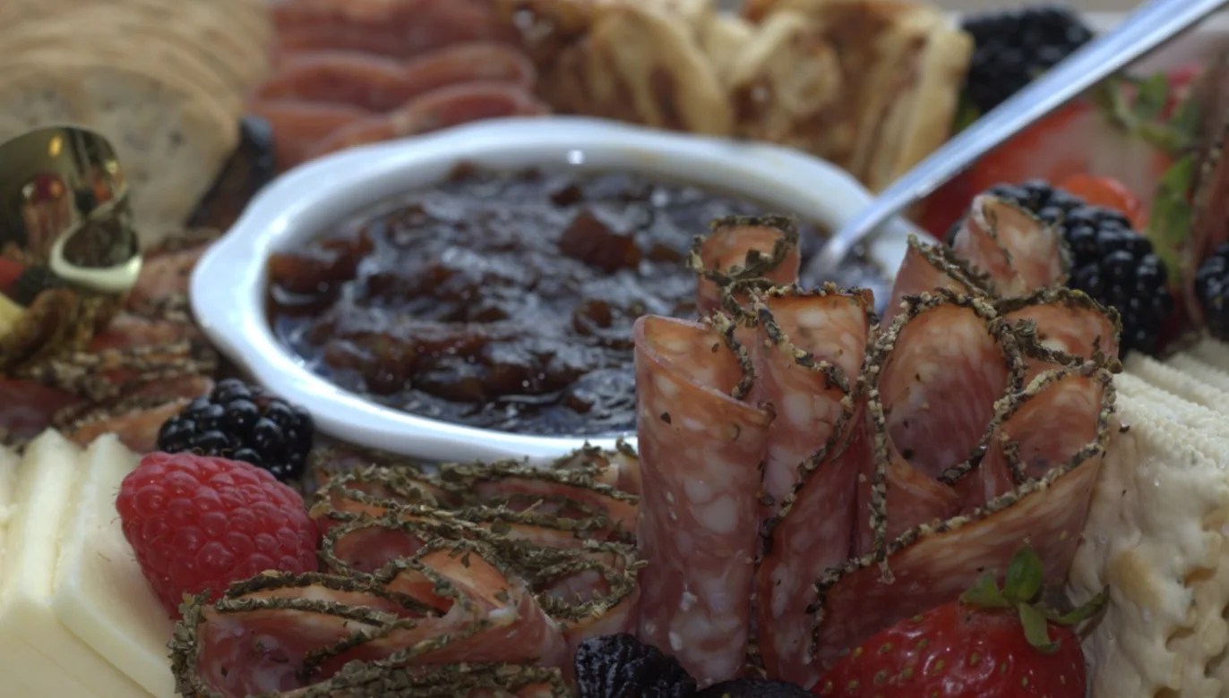 Sliced meats and accompaniments on the grazing table.